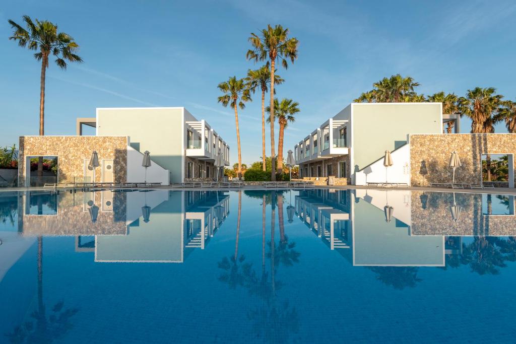 科斯镇Apollon Windmill Boutique Hotel - Adults Only的棕榈树环绕的度假村游泳池