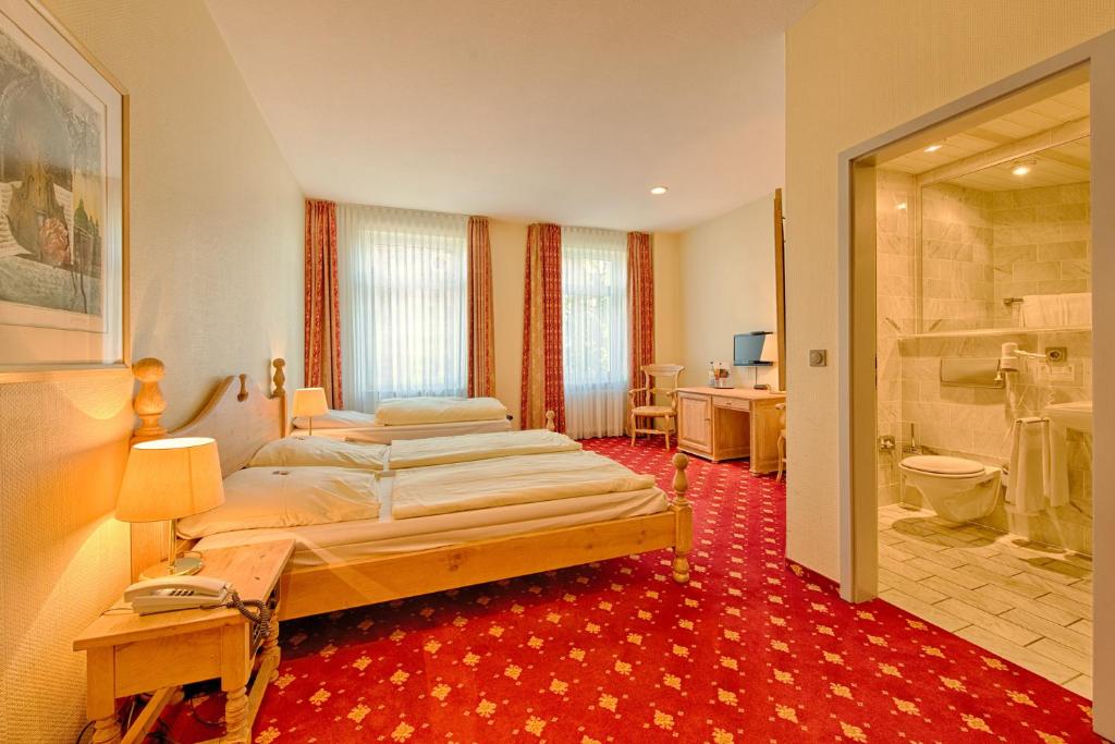 明登科隆帕丽泽咖尼酒店的一间带两张床的卧室和一间浴室