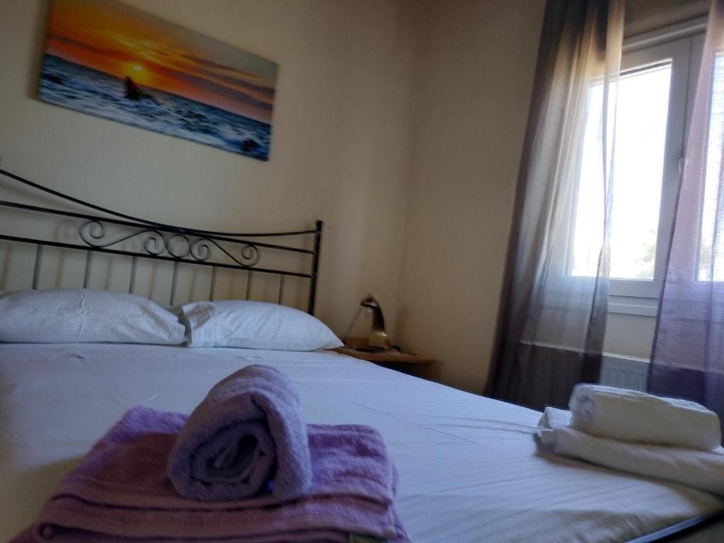 阿特米达Near AirportAnd metropolitan Penelopi Cozy Home的一间卧室配有一张床,床上有毛巾