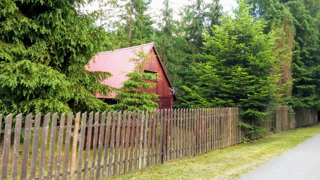 GlinkaChatka Nad Strumieniem的围栏后面的红房子旁边围栏