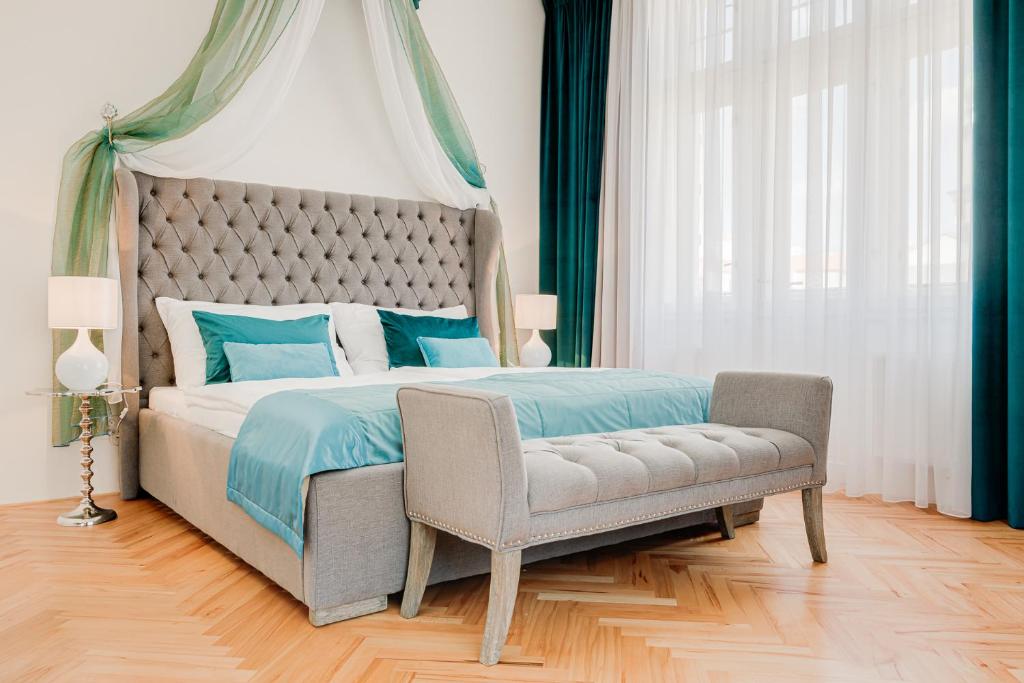 布拉格Gold Art Apartments的一间卧室配有一张大床和一把椅子