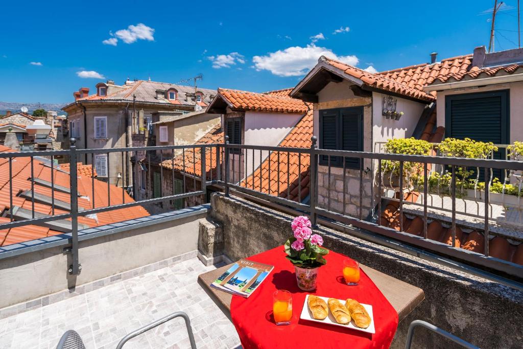 斯普利特Rooftop city view apartment in the palace walls的阳台配有餐桌,上面有食物