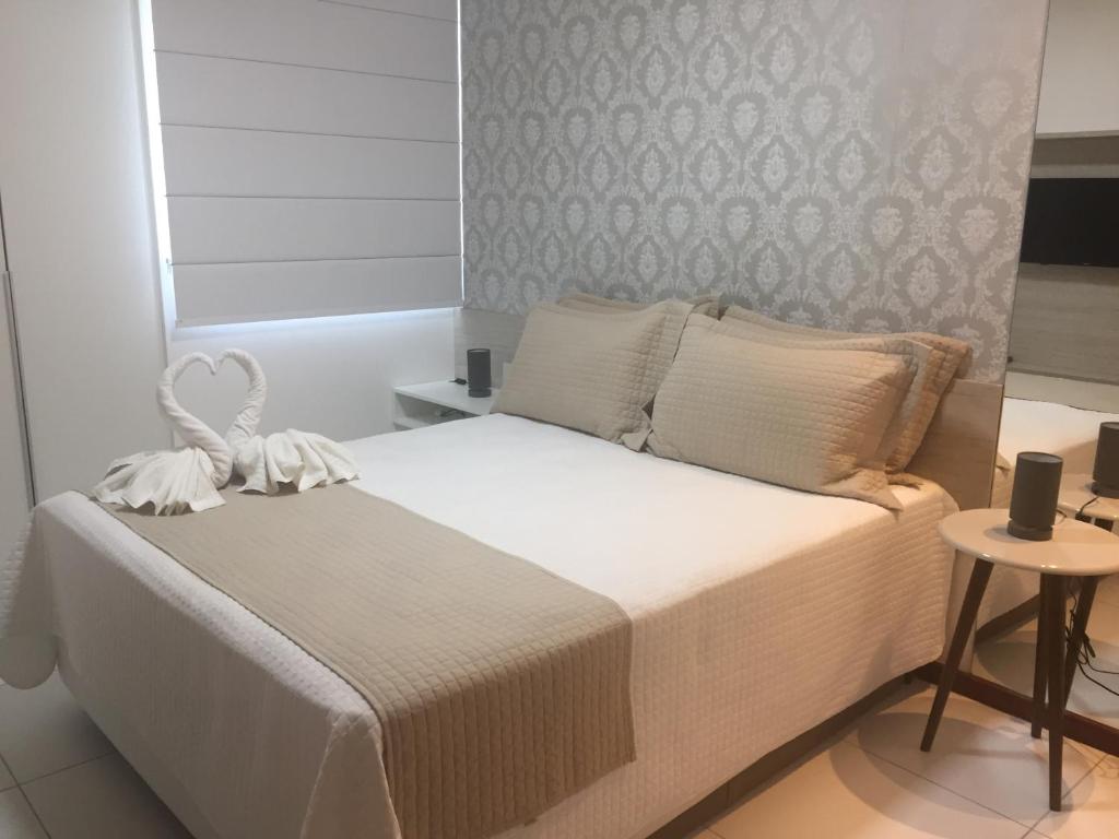 拉巴拉德纳圣米格尔Apto Luxo Iloa Barra de São Miguel的卧室配有一张白色的大床和一张桌子