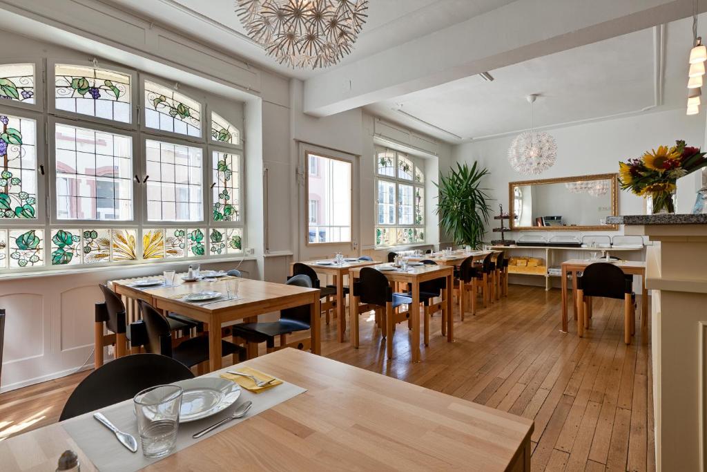 罗拉赫赛本达斯安迪乐酒店的餐厅设有木桌、椅子和窗户。