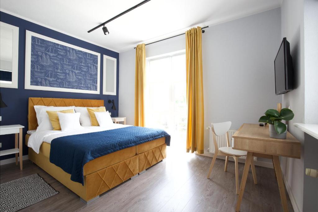 格丁尼亚Villa Orla的一间卧室配有一张蓝色墙壁的床和一张书桌