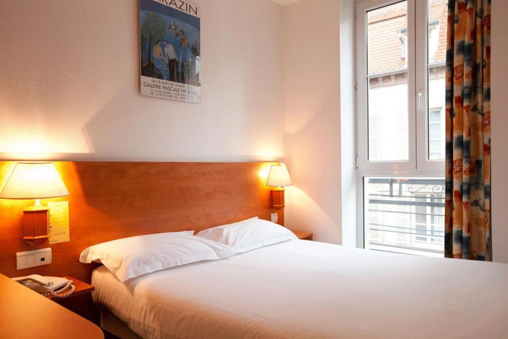 斯特拉斯堡21世纪酒店的卧室配有白色的床和窗户。