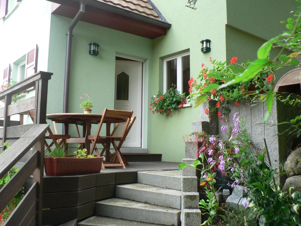 Ueberstrass吉特德拉里斯尔瑞博奥斯度假屋的一个带门廊的小房子,带桌子和鲜花