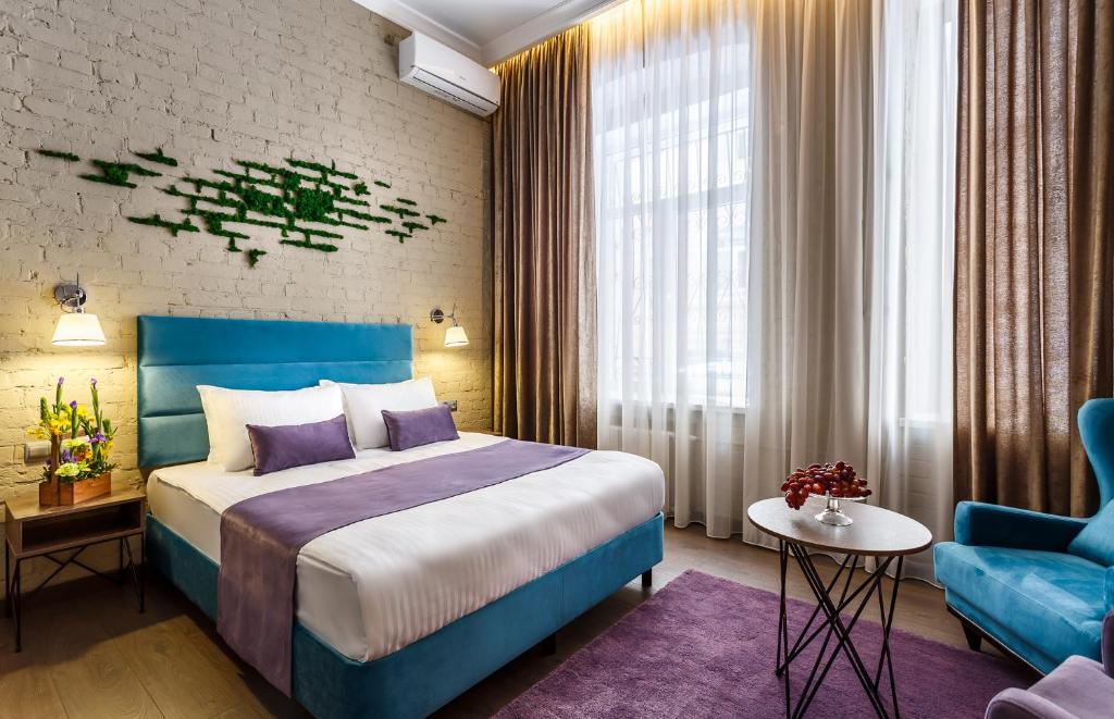 莫斯科Mansilion Hotel的一间卧室配有蓝色的床和蓝色椅子
