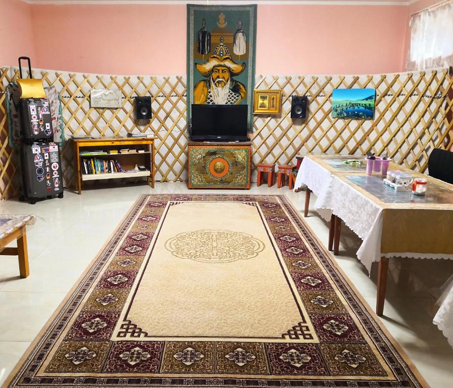 乌兰巴托Town Yard Hostel的一间铺在地板上的地毯和桌子的房间