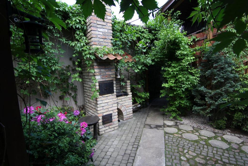 苏普拉希尔Apartamenty pod Wiciokrzewem的一座花园,花园内有砖砌的植物和花卉