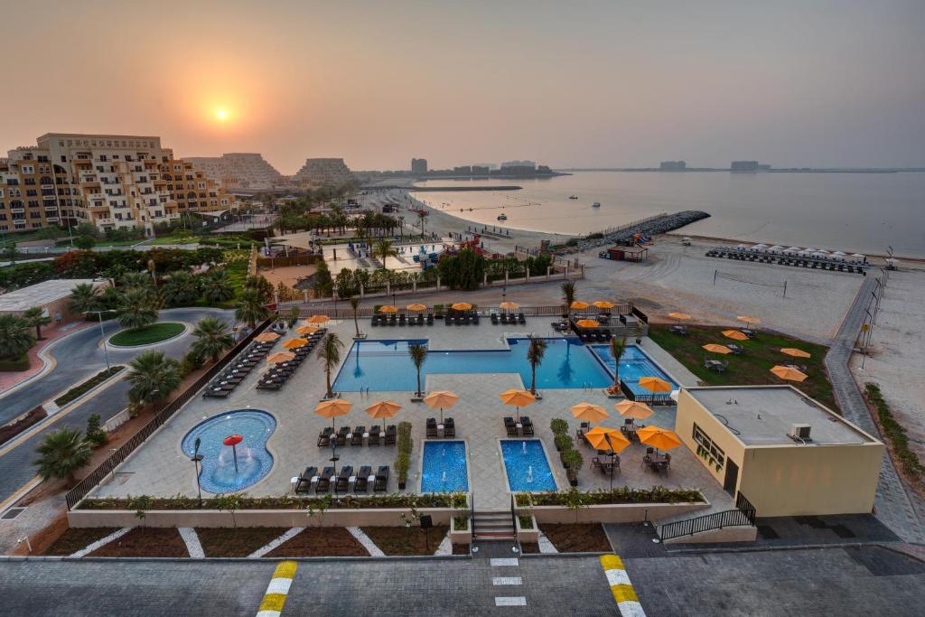 拉斯阿尔卡麦City Stay Beach Hotel Apartments - Marjan Island的享有带游泳池和遮阳伞的度假村的空中景致