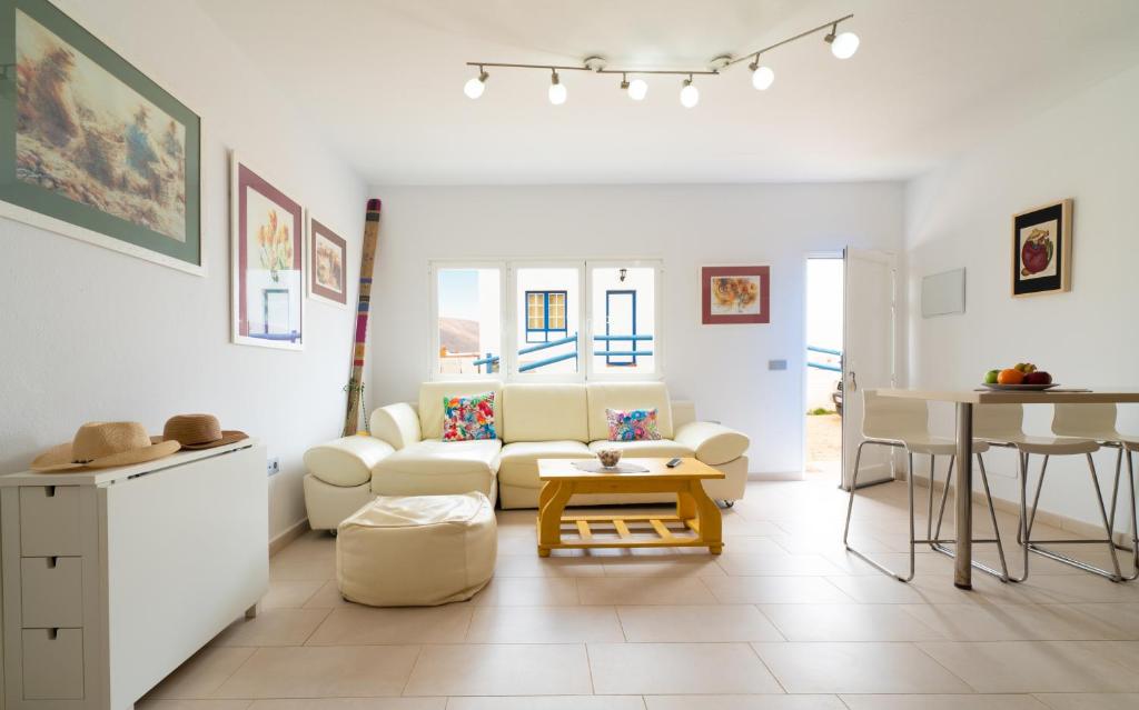 塞博河畔卡莱塔APARTAMENTO LOS REMOS DE LA GRACIOSA的客厅配有白色的沙发和桌子