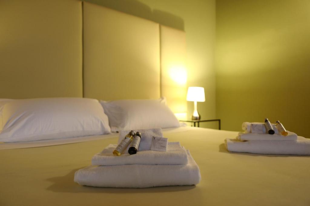 佩斯基耶拉德加达Osteria Luxury Apartments的酒店客房的床上配有2条毛巾