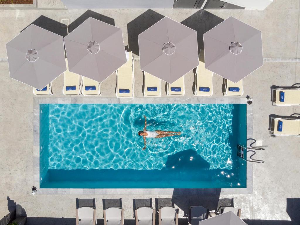 普拉塔尼亚斯Athina Suites Platanias的享有带遮阳伞的游泳池的顶部景致