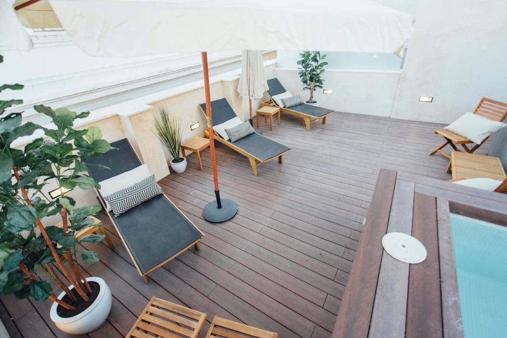 塞维利亚One&Lux Byron Suites的享有带椅子和游泳池的顶部景致