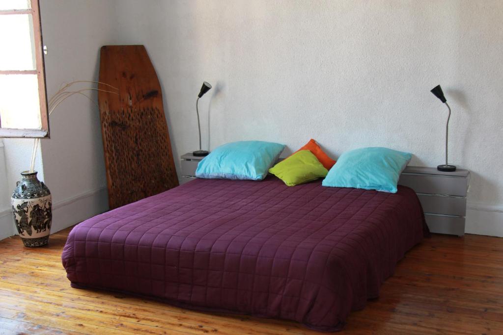 西埃勒河畔科尔德Chambre cozy et Salon de 60 m2 au coeur de la cité的一间卧室配有一张带两个枕头的紫色床