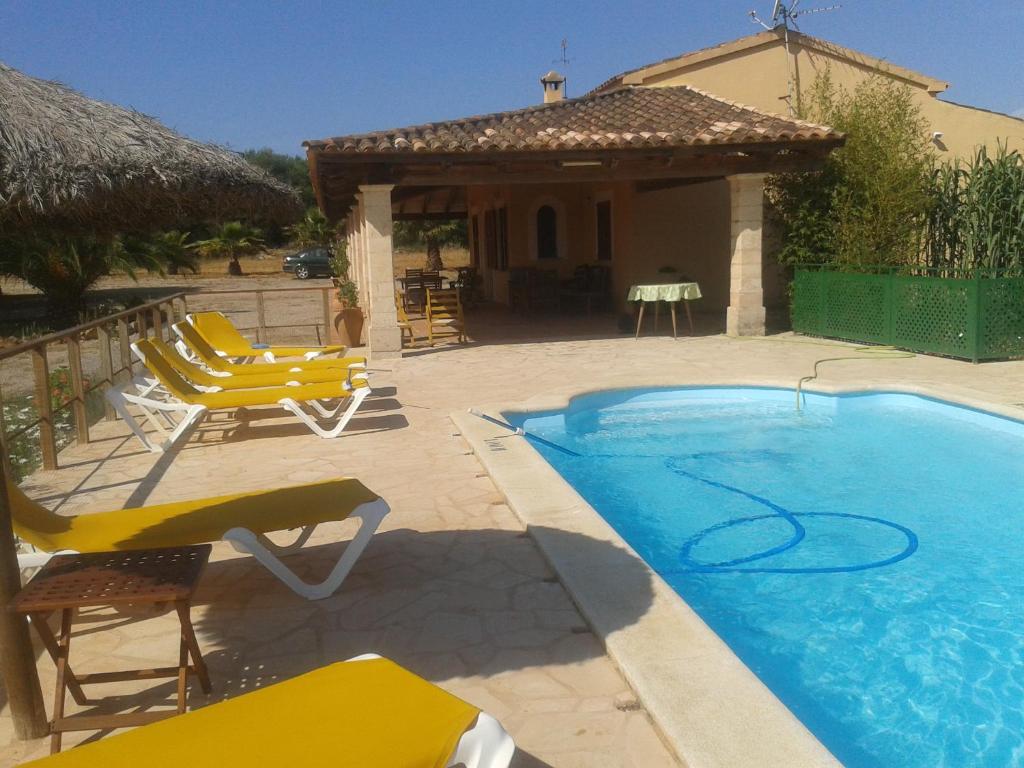 坎波斯Casa Rural cerca Es Trenc的一座带黄色椅子的游泳池