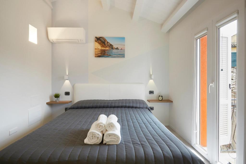 锡罗洛Affittacamere Somnium的一间卧室配有一张带两张白色拖鞋的床