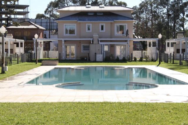 皮纳马尔Complejo Tridente的房屋前有游泳池的房子