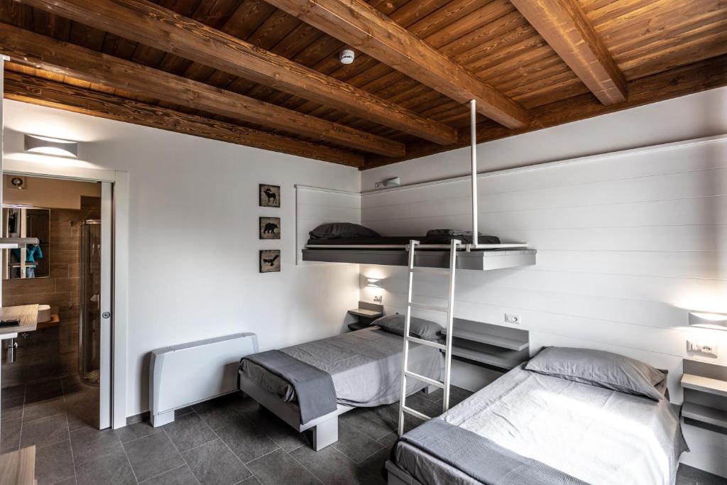 Settimo VittoneMiglio608的一间卧室设有两张双层床和木制天花板。