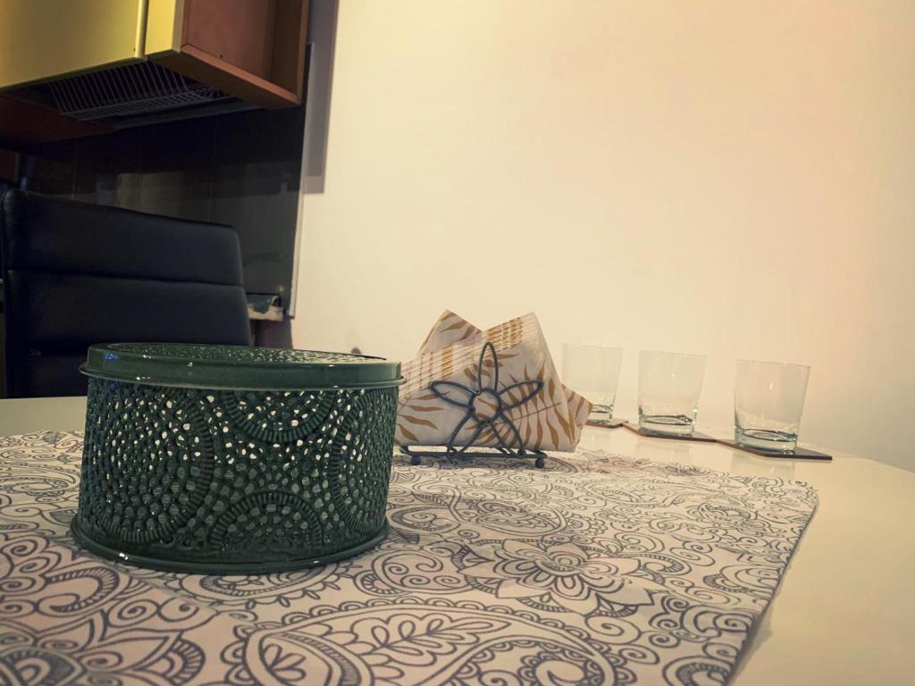 札勒乌Lux Apartament的绿色垃圾可以坐在桌子上,放两杯