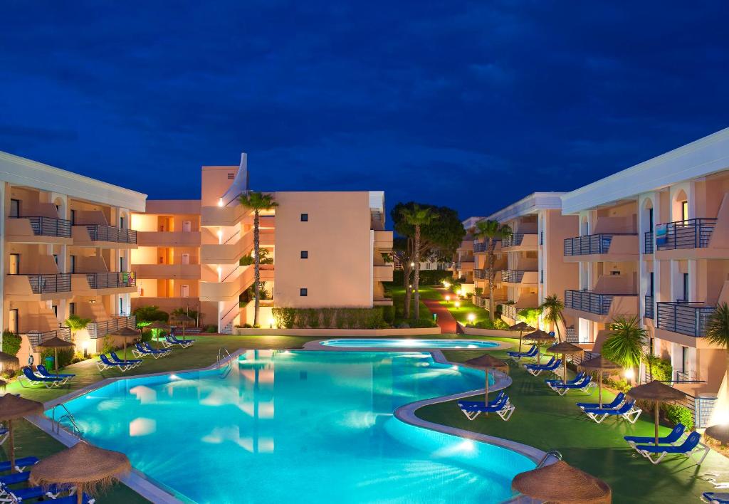 奇克拉纳－德拉弗龙特拉索尔桑克蒂佩特里公寓式酒店的夜间在酒店前的游泳池
