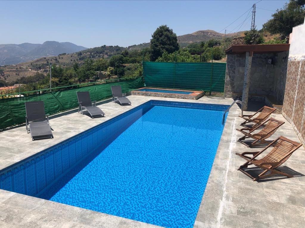 兰哈龙El Aguacate的一个带椅子的蓝色游泳池和一个泳池景