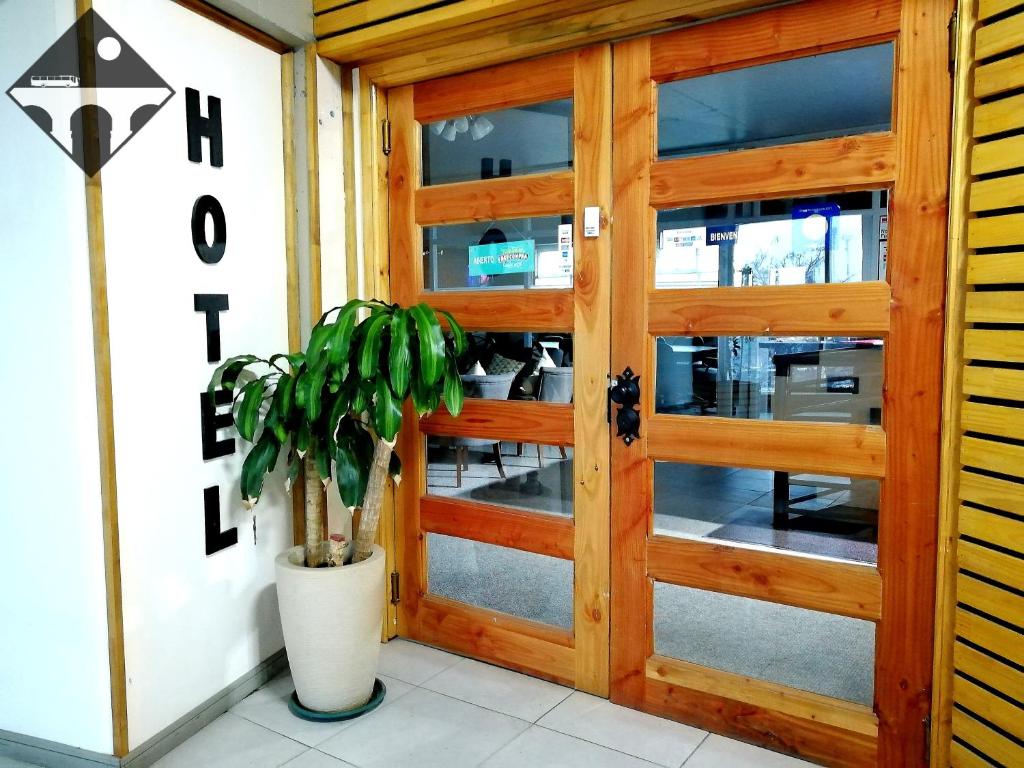 瓦尔迪维亚Hotel Terra Valdivia的木门,前面有盆栽植物