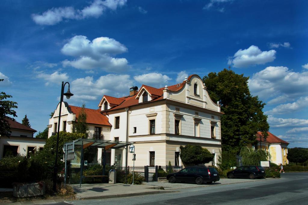 Dolní Lukavice海顿楼旅馆的一座大型白色房屋,设有红色屋顶