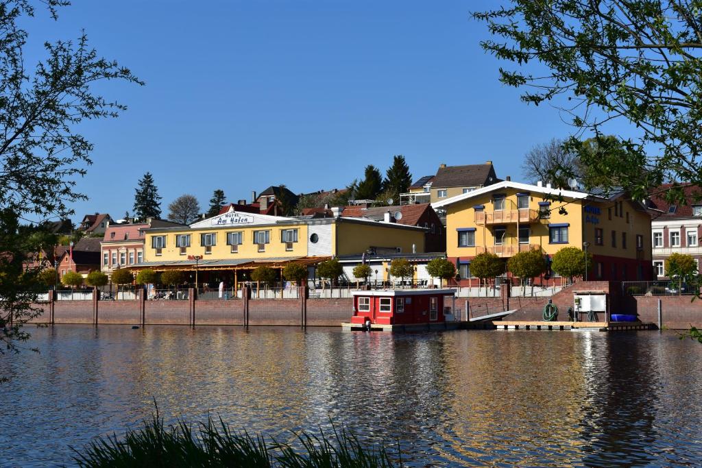 哈弗尔贝格Hotel garni "Am Hafen"的一条河,河里有房子,水里有一艘红船
