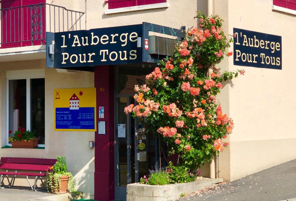瓦洛尔布Auberge Pour Tous的商店前有花丛的建筑物