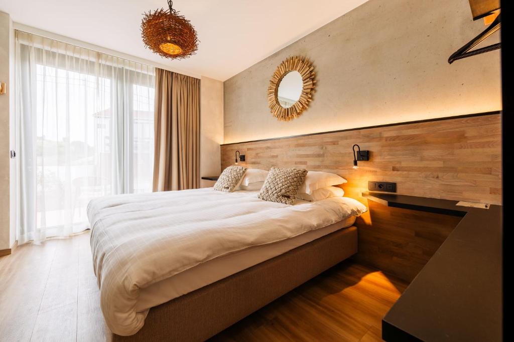 米德尔克尔克C-Hotels Zeegalm的一间卧室配有一张大床和镜子