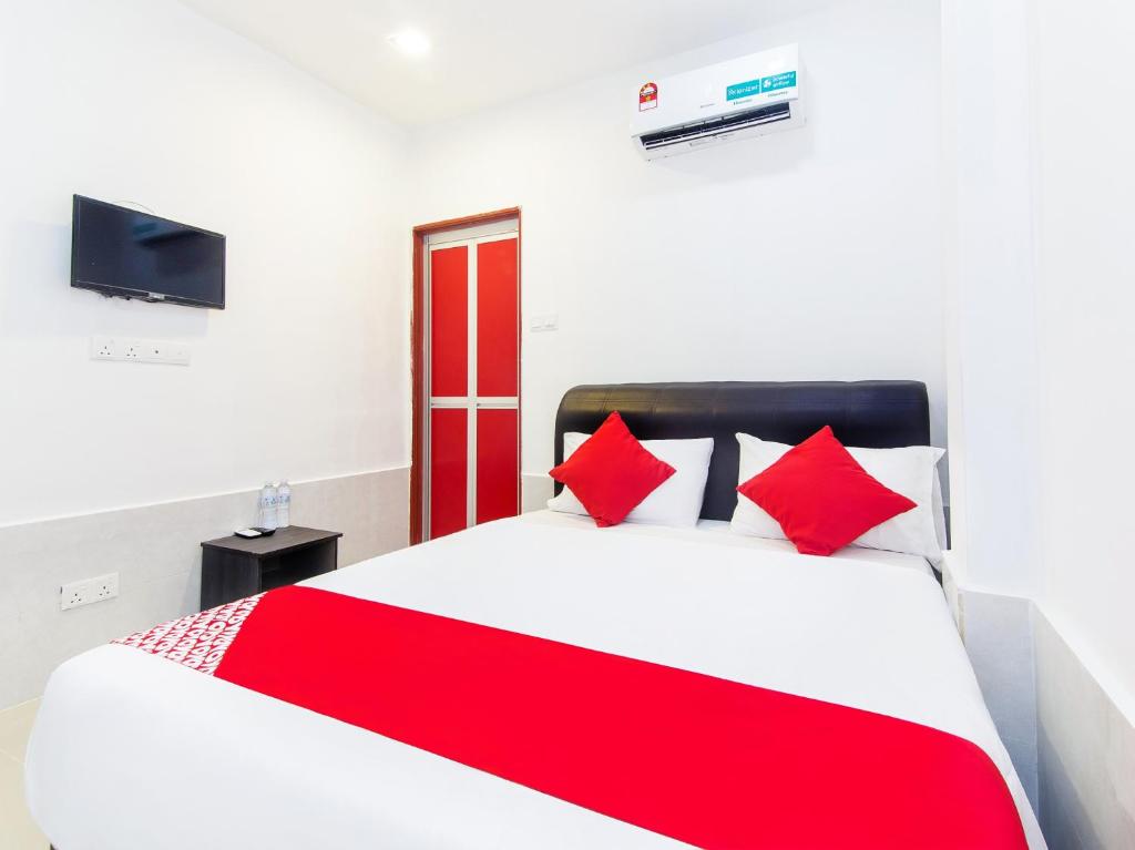 雪邦Super OYO 414 Adiff Palace Hotel的卧室配有带红色枕头的大型白色床