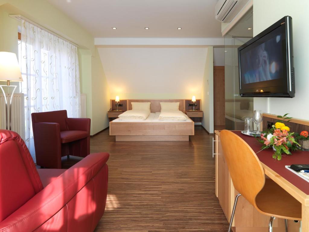 加姆利茨维恩古特什科夫奥利吉诺旅馆的客厅配有一张床和墙上的电视