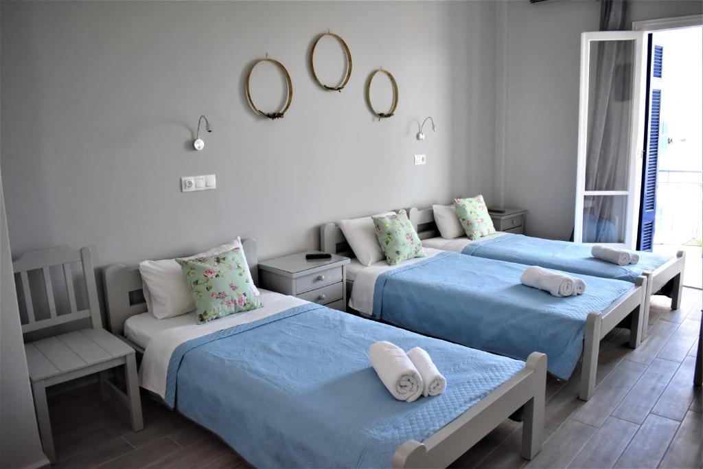 爱琴娜岛Aphrodite Art Hotel Aegina的一间卧室设有三张床、一把椅子和镜子