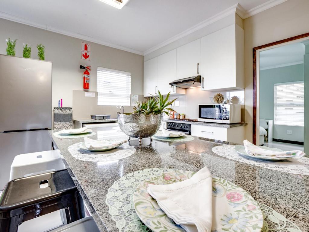 德班Westwood Skye 12 Grace Avenue的厨房配有白色橱柜和花岗岩台面