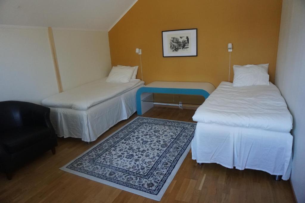 韦斯特罗斯IzKaMaGe Hotel的客房设有两张床和一张蓝色的桌子。