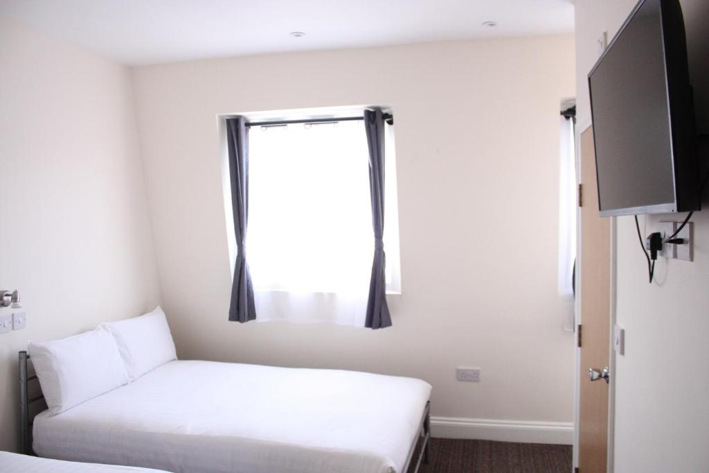 伦敦Daisy Hotel的小房间设有床和窗户