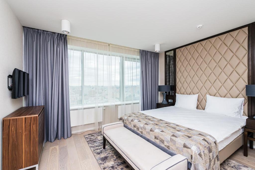 莫斯科Apart-Hotel Intermark Residence on Novy Arbat, 15的酒店客房设有一张床和一个大窗户