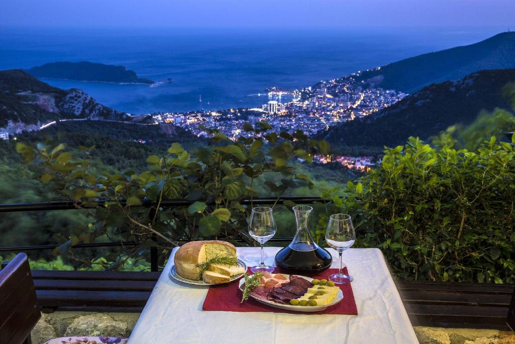 布德瓦Villa Nera的一张桌子,上面放着两盘食物和酒杯