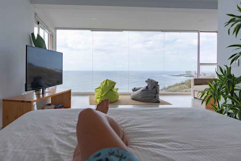 巴哈马尔Waves Nest - Bajamar的躺在电视房床上的人