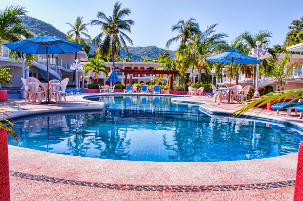 阿卡普尔科柯斯达阿祖酒店的度假村的游泳池,配有椅子和遮阳伞