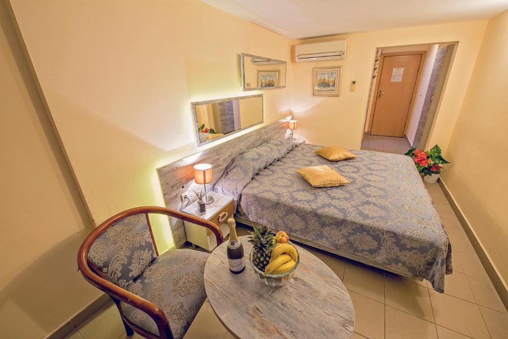 瓦尔纳维多利亚大酒店的小卧室配有一张床和一张桌子,上面放有香蕉