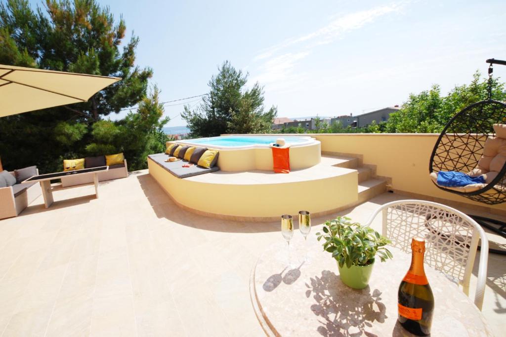卡什泰拉Apartmant with Pool 8的天井配有沙发和1张带1瓶葡萄酒的桌子。