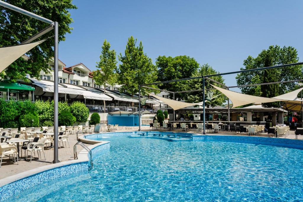 韦莱斯罗曼蒂克韦莱斯酒店的一个带桌椅的大型游泳池