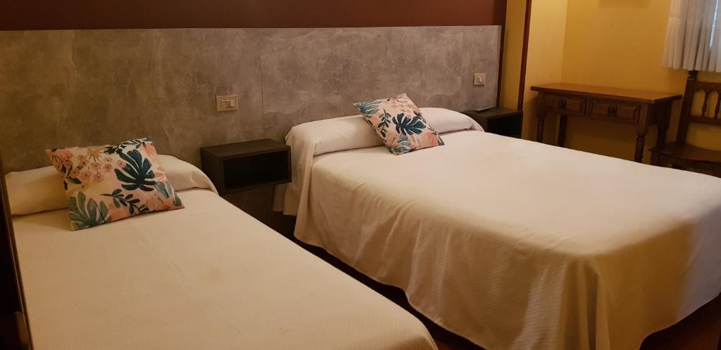 卢戈Hostal Fisterra的酒店的客房 - 带两张床和枕头
