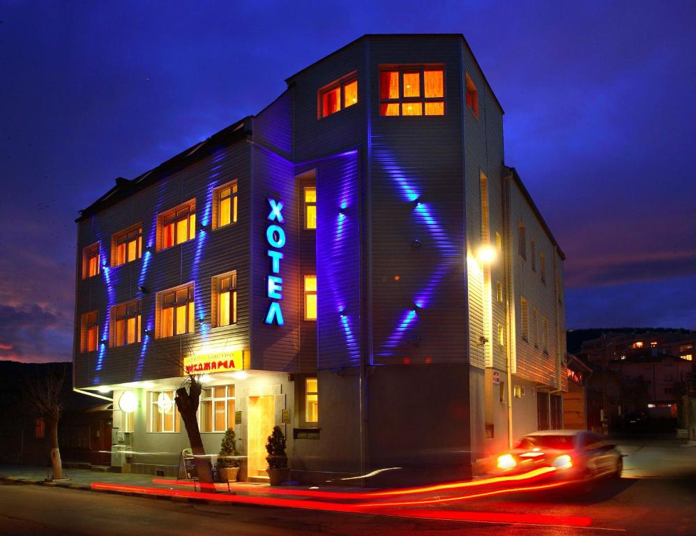 舒门梅赫德加莱尔酒店的一座晚上在上面标有蓝色标志的建筑