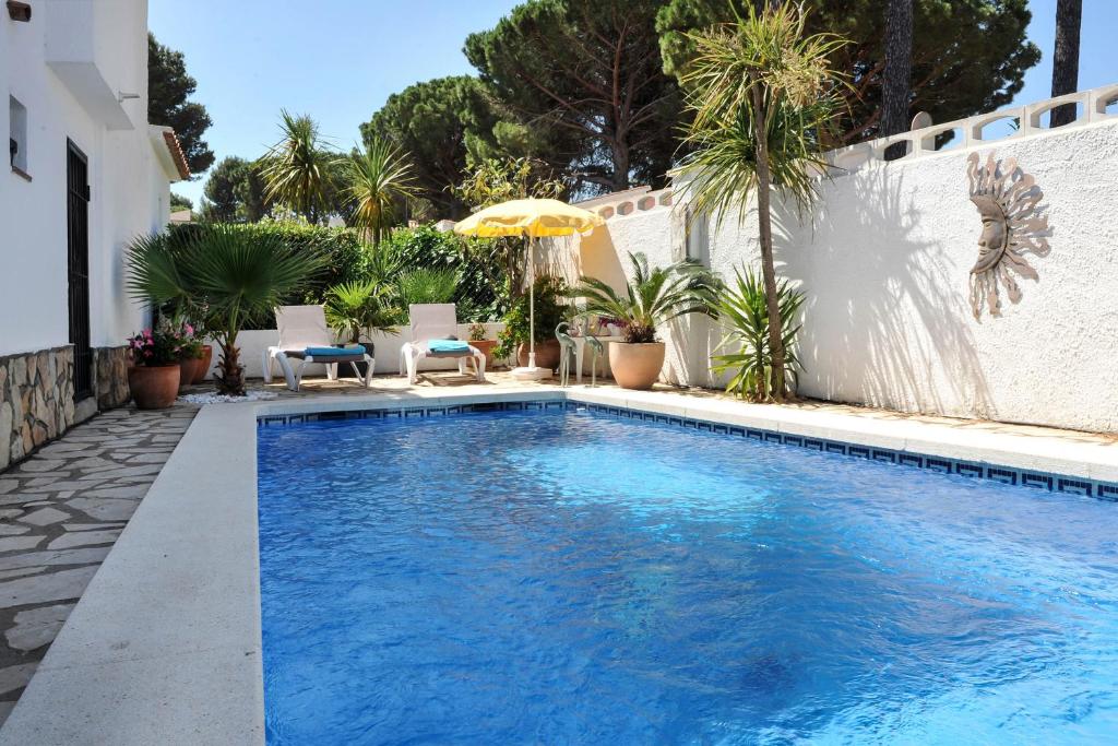 莱斯卡拉Pi gran a的后院的游泳池,有白色的围栏和棕榈树
