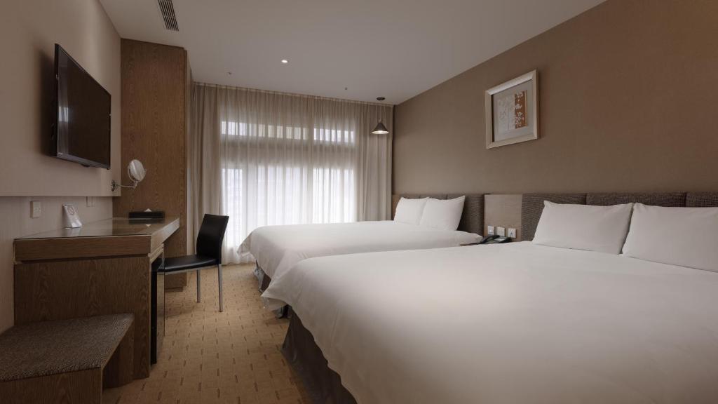 高雄好地方大饭店三多馆的酒店客房设有两张床和电视。