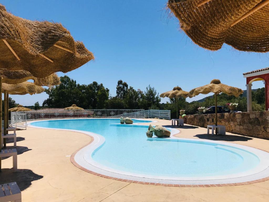 布多尼佩德拉尼尔达酒店的度假村的游泳池,配有遮阳伞